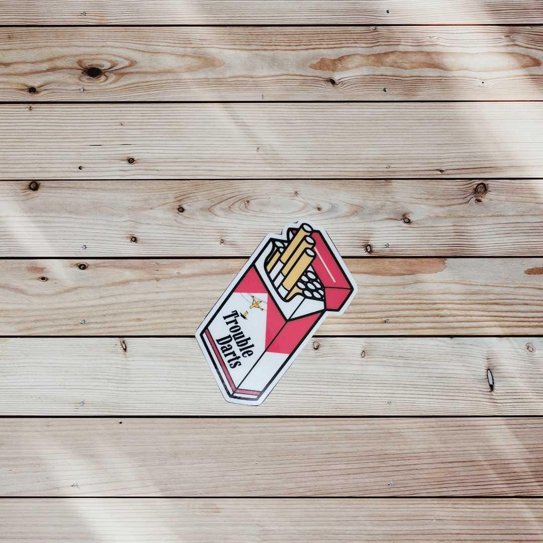 Red and White Trouble Darts Cigarette Pack Vinyl Sticker | 2x2